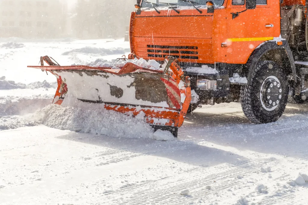 Winterdienst im Einsatz: Ein Schneepflug räumt die Straße frei bei schwerem Schneefall.